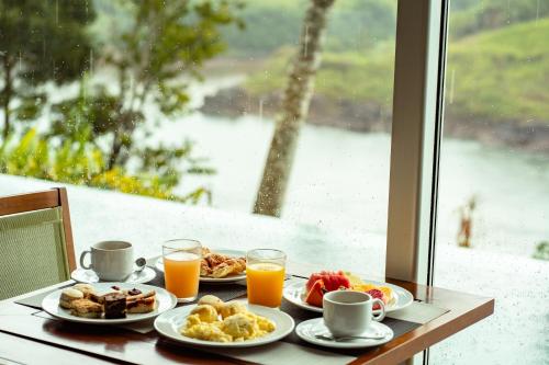 a table with plates of breakfast food and orange juice at Hotel Guaminí Misión in Puerto Iguazú