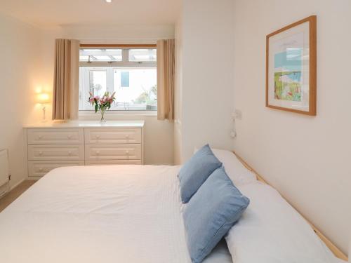 a bedroom with a white bed with a blue pillow at Lysander in Kingsbridge