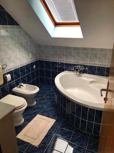 a bathroom with a tub and a toilet and a sink at Greencajt in Jakopovec