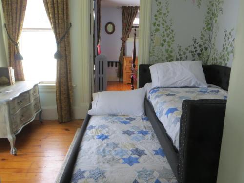 a small bedroom with a bed and a dresser at Cooperstown Bed and Breakfast in Cooperstown