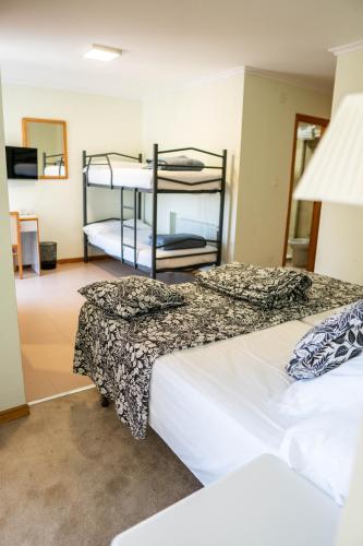 zwei Betten in einem Zimmer mit zwei Etagenbetten in der Unterkunft Hotel Playa de Merón in San Vicente de la Barquera