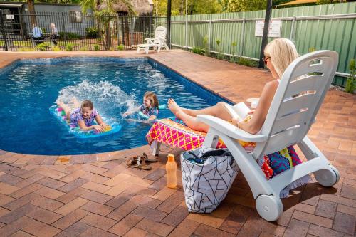 una mujer y dos niños jugando en una piscina en Adelaide Caravan Park - Aspen Holiday Parks, en Adelaida