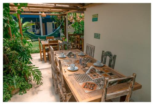 a wooden table and chairs in a patio with a table and chairs at Pousada Mar Azul in Trancoso