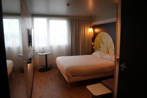 a hotel room with a bed and a window at ibis Styles Le Treport Mers Les Bains in Mers-les-Bains