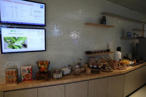 a counter in a kitchen with a menu on the wall at ibis Styles Le Treport Mers Les Bains in Mers-les-Bains