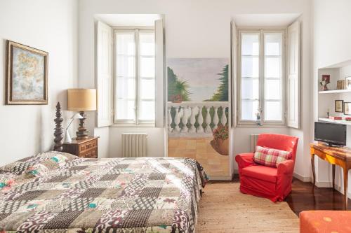una camera con letto e sedia rossa di Villa Niobe - Exclusive Lakefront Apartment With Private Beach a Stresa