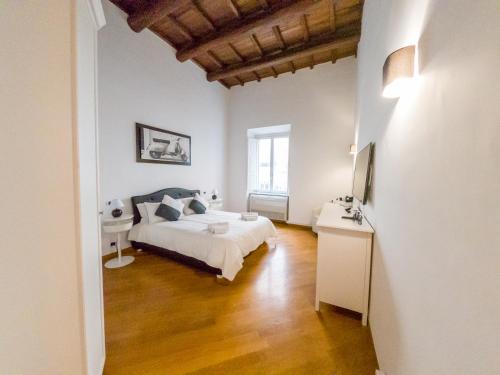 Schlafzimmer mit einem weißen Bett und Holzboden in der Unterkunft Pandy Suite in Rom