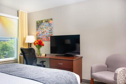 a bedroom with a bed and a tv and a chair at Belltown Inn in Seattle