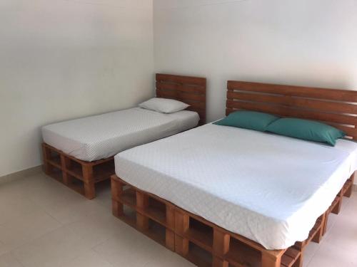 two twin beds in a room withermottermottermott at Villas del Guali - Piscina Privada in Santa Fe de Antioquia