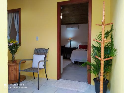 a room with a chair and a room with a bed at Pousada João Maria in Trancoso
