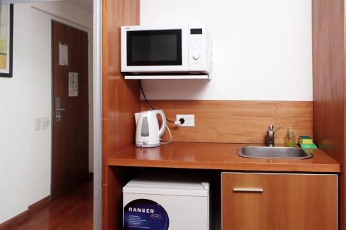 a white microwave sitting on top of a kitchen counter at Catamarca Suites Land in Rosario