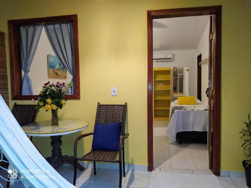 a room with a table and chairs and a bedroom at Pousada João Maria in Trancoso