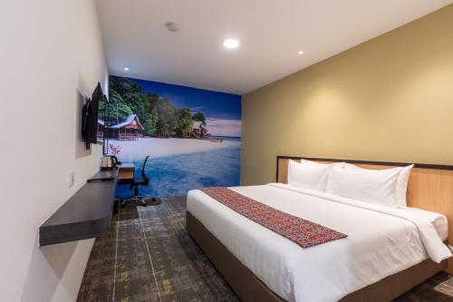 a bedroom with a bed and a painting of a beach at Hotel 7 Suria in Kota Kinabalu