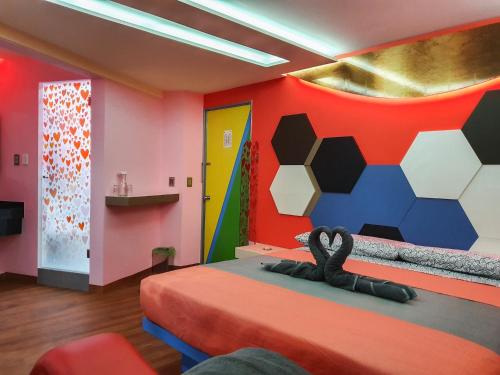 ein Schlafzimmer mit einem Bett mit einer farbenfrohen Wand in der Unterkunft Hotel Río in Mexiko-Stadt