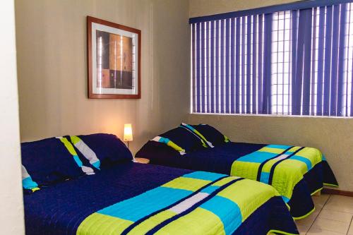 a hotel room with two beds and a window at Gdl Collection for families in Guadalajara