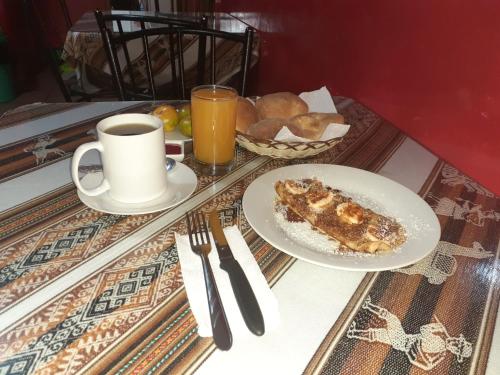 a table with a plate of food and a cup of coffee at Krusty Hostel B&B in Huaraz