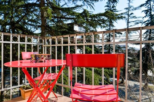 twee rode stoelen en een rode tafel op een terras bij Apartment on Rustaveli Avenue in Koetaisi