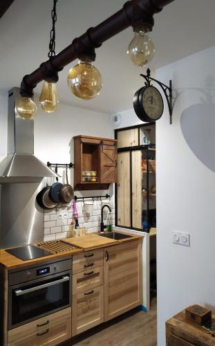 une cuisine avec une cuisinière et une horloge au mur dans l'établissement Carré des Halles Centre Historique, à Bayonne
