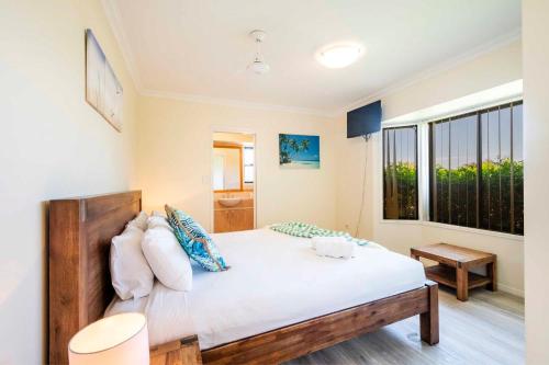 a bedroom with a bed and a large window at Oceania 11 - LJHooker Yamba in Yamba