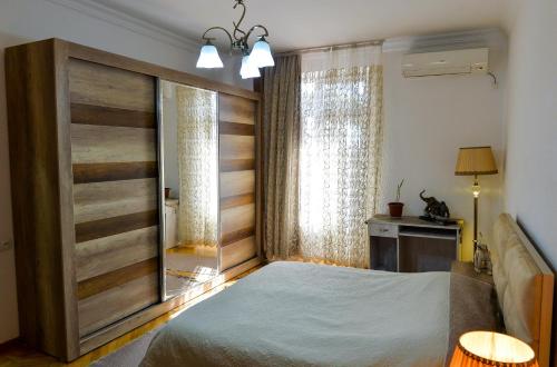 een slaapkamer met een groot bed en een raam bij Apartment on Rustaveli Avenue in Koetaisi