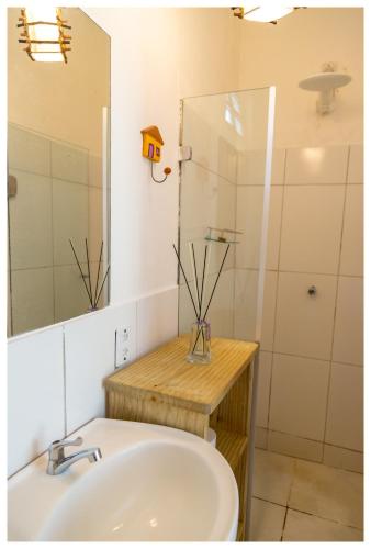 a bathroom with a sink and a mirror and a shower at Pousada Mar Azul in Trancoso