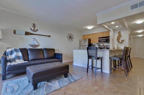 a living room with a couch and a kitchen at 202-Pool, WIFI, Close to BUCS STADIUM in Tampa