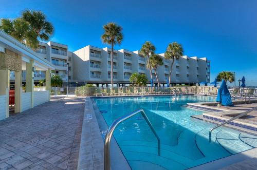 a swimming pool in front of a building with palm trees at 202-Pool, WIFI, Close to BUCS STADIUM in Tampa