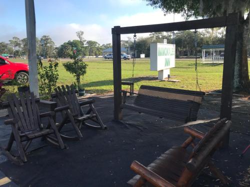 three chairs and a swing in a park at Immokalee Inn in Immokalee