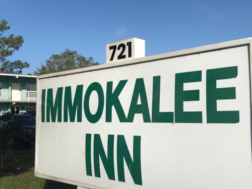 a white sign with the on top of it at Immokalee Inn in Immokalee
