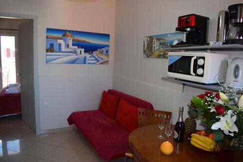 een woonkamer met een tafel en een magnetron bij Alena Apartments in Chania