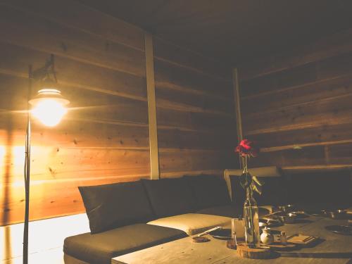 a living room with a couch and a table with a flower at sana mane in Naoshima