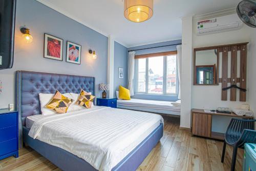 um quarto azul com uma cama e uma janela em Miah Boutique Homestay em Hanói