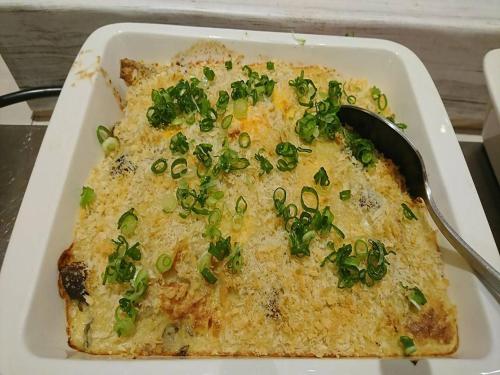 a casserole dish of food with green onions on it at Hotel Kuretakeso Hiroshima Otemachi in Hiroshima