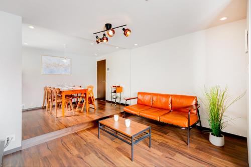 a living room with a couch and a table at Chikyuutabikazoku USJ Ⅱ in Osaka