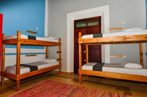 a room with two bunk beds and a rug at Hostal La 59 in Mérida