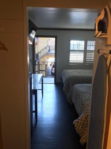 a room with two beds and a table and a window at Westwind Lodge in Oakland