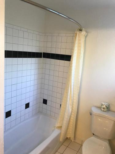 a bathroom with a white tub and a toilet at Westwind Lodge in Oakland