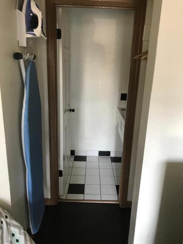 a hallway with a door to a bathroom with a tile floor at Westwind Lodge in Oakland