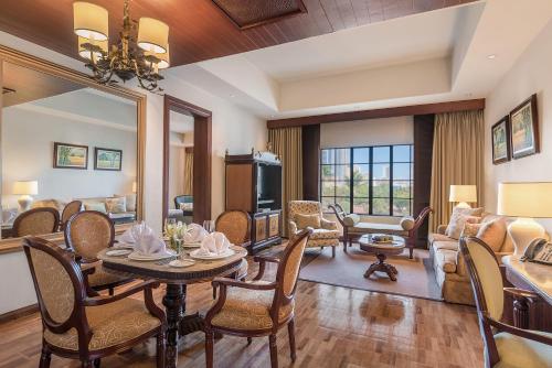a dining room and living room with a table and chairs at The Manila Hotel in Manila