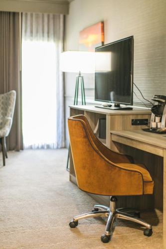 a chair in a hotel room with a flat screen tv at The Ridges Resort on Lake Chatuge in Young Harris