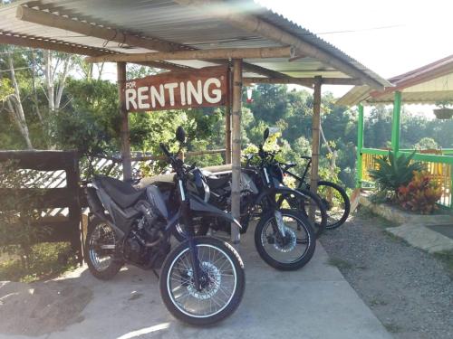 a couple of motorcycles parked under a roof at Hostal y Camping Los Girasoles in Salento