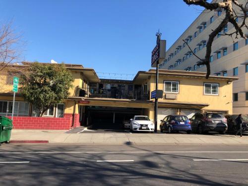a building with cars parked in a parking lot at Westwind Lodge in Oakland