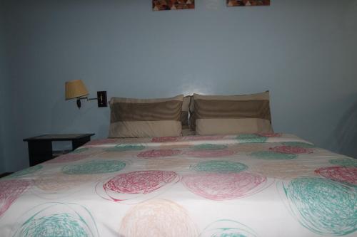 a large bed with a colorful blanket on it at Yoo C Apartment in Dumaguete