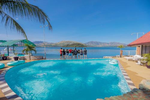 a group of people standing in front of a swimming pool at Whiterock Beach Hotel and Waterpark in Subic
