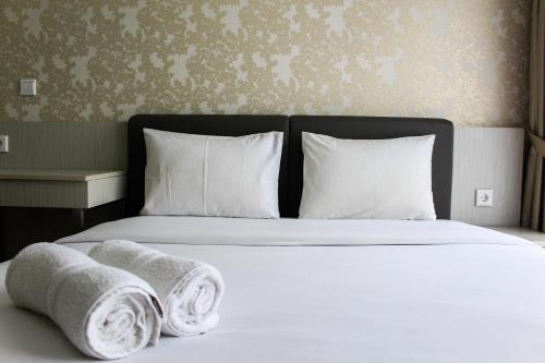 a bedroom with a bed with towels on it at Minimalist 1BR Apartment at M-Town Signature By Travelio in Pumpangsineng