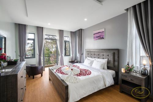 1 dormitorio con 1 cama, escritorio y ventanas en Hong Mon Villa en Da Lat