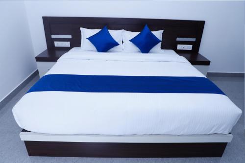 a blue and white bed with blue pillows on it at Casillda Munnar in Munnar