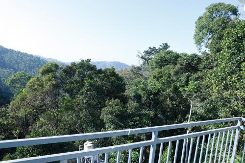 a white railing with trees in the background at Casillda Munnar in Munnar