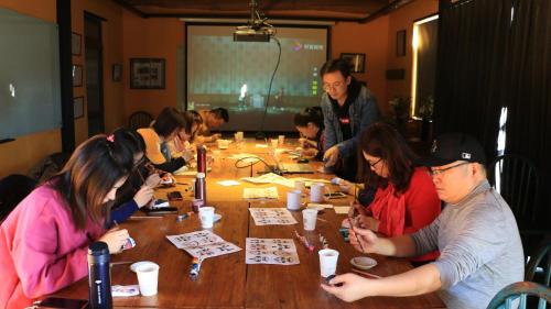 a group of people sitting around a table playing cards at Brickyard Retreat at Mutianyu Great Wall Adjoin to Mutianyu Great Wall - Room with the View of Great Wall - Chinese massage experience - Vehicle Shuttle Service - International Catering - SPA& Nail Beauty Facilities in Huairou
