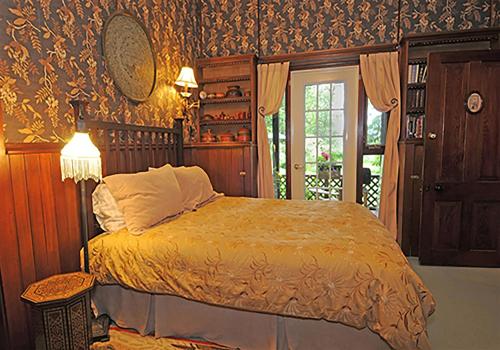 a bedroom with a bed in a room with wallpaper at Wedgwood Manor and Glamping Retreat in Crawford Bay